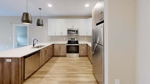 Kitchen with stainless steel appliances and wood cabinetry at The Confluence Apartments, Easton, PA