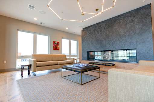 A living room with a couch, coffee table, and fireplace.