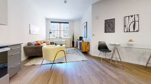 A living room with a yellow chair and a brown couch.