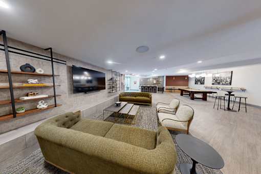 A living room with a green couch and a television at The Standard Apartments, Allentown, PA