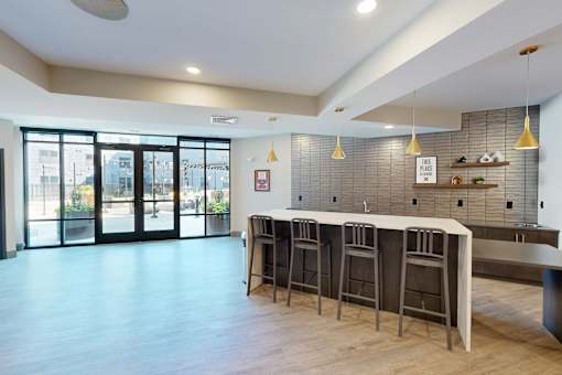 A bar area with a row of stools and a counter at The Standard Apartments, Allentown