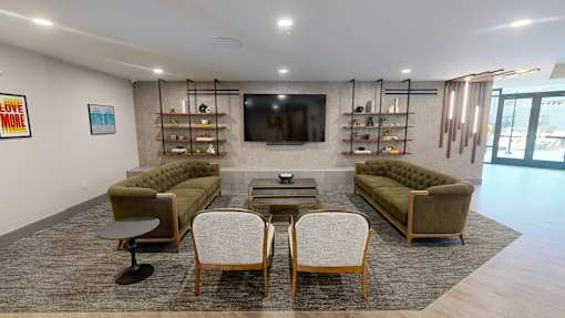 A living room with a green couch, two chairs, and a coffee table at The Standard Apartments, Pennsylvania