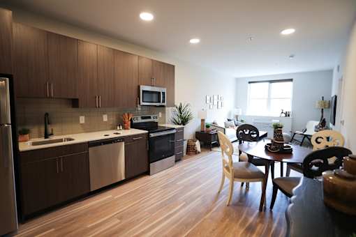 A modern kitchen with wooden floors and furniture.