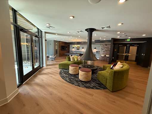 A modern living room with a green armchair and a black floor lamp.