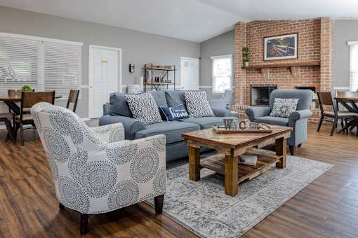 A living room with a brick fireplace and a grey sofa at Pointe North Apartments, Bethlehem, PA.
