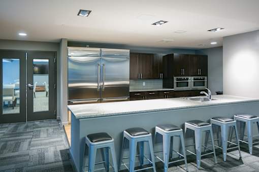 a large kitchen with a bar with blue stools