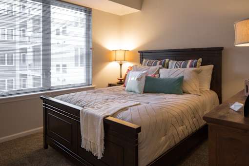 a bedroom with a bed and a large window