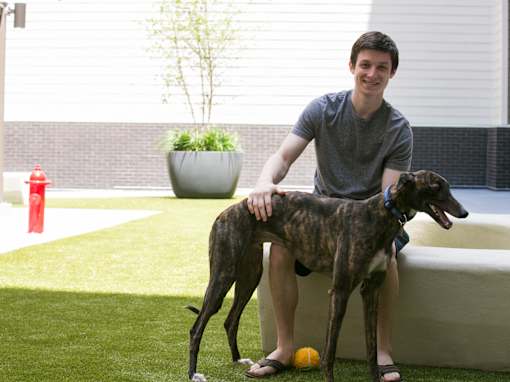 a man sitting on a couch with his two dogs