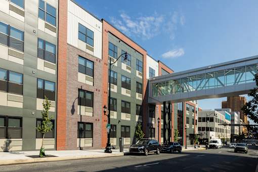 A modern building with a glass walkway over the street.