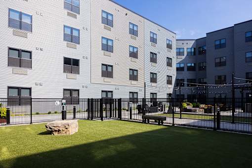 A large building with a fence and a bench in front of it.