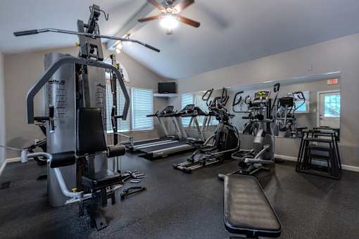 A gym with a variety of equipment including treadmills, elliptical machines, and a weight bench. at Meadows Apartments, Emmaus, PA, 18049