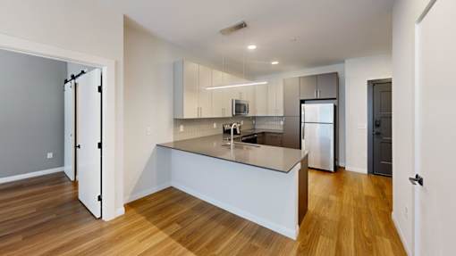 A modern kitchen with a wooden floor and white walls at The Standard Apartments, Pennsylvania, 18101