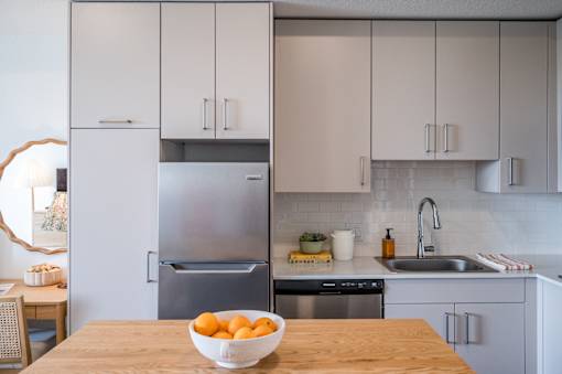 A kitchen with a bowl of oranges on the table.at The Teale Golden Gate in Naples, FL, 34116