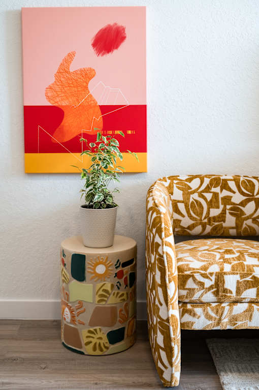 A painting on the wall, a plant, a table and a chair at The Teale Golden Gate in Naples, FL, 34116