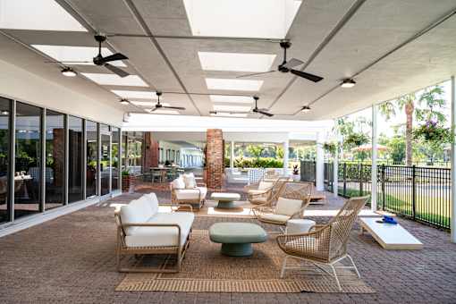 A patio with a table and chairs and a fan.
