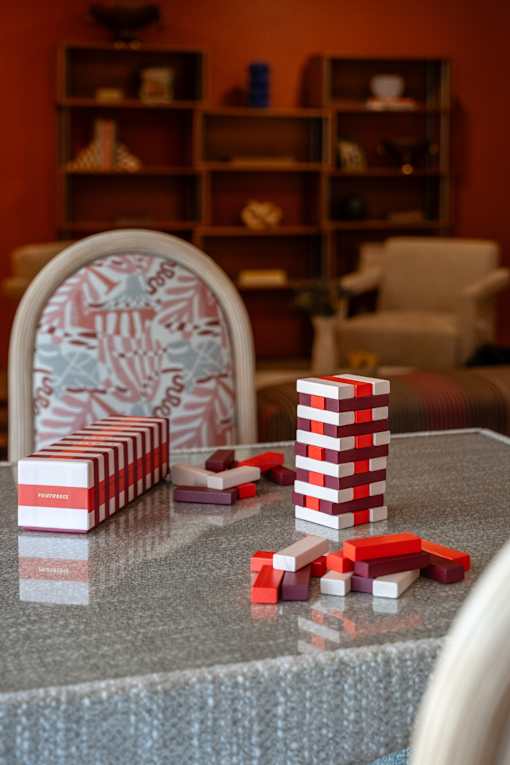 A table with a stack of red and white cups and a pile of red blocks on it.