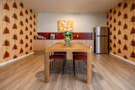A dining room with a wooden table and chairs.