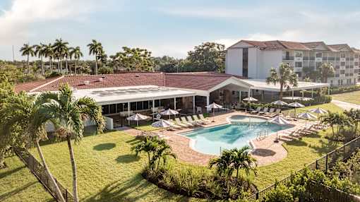 A large building with a pool in front of it.