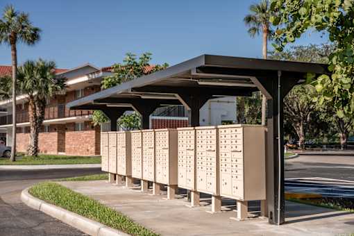 A row of mailboxes are lined up under a roof.