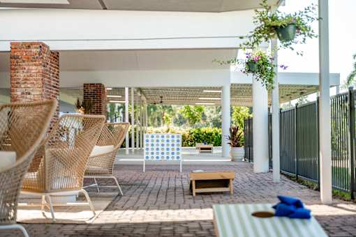 A patio with a white awning and a striped cushion on a chair.