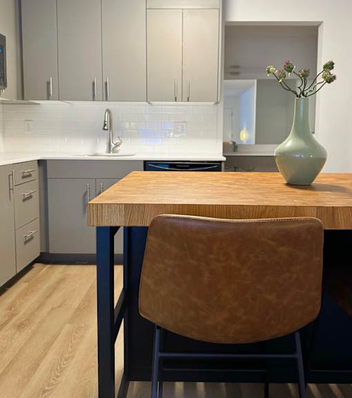 A kitchen with a wooden table and a brown chair at The Teale Siesta Lago in Kissimmee, FL, 34746