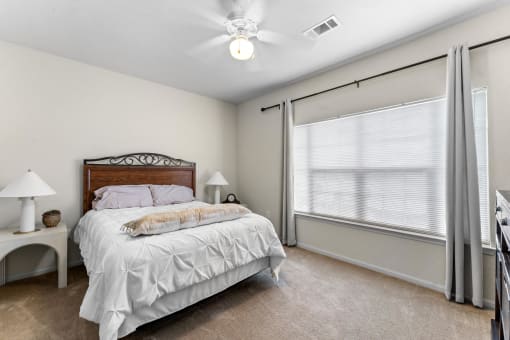 a bedroom with a large window and a bed