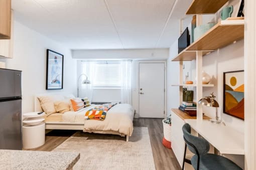 a bedroom with a bed and a refrigerator and a window at The Teale Navy Yard, North Charleston, South Carolina