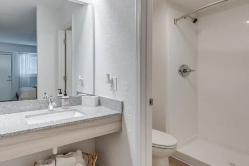 a bathroom with a sink and a shower and a mirror at The Teale Navy Yard, North Charleston