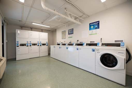 A row of washing machines in a laundromat. at The Teale Golden Gate in Naples, FL, 34116