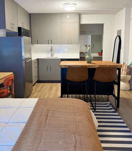 A kitchen with a refrigerator, sink, and cabinets. at The Teale Golden Gate in Naples, FL, 34116