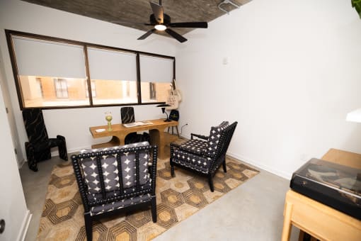a living room with two chairs and a desk and a ceiling fan  at The Lady, South Carolina, 29201