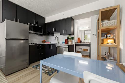 A kitchen with a blue table and white chairs.