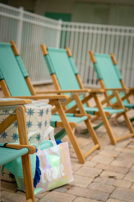 A row of blue and white beach chairs are lined up on a patio.