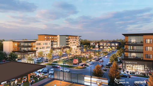 A city street with cars and buildings with a sign at The District at Deerfield Residences Apartments, Mason, OH, 45040