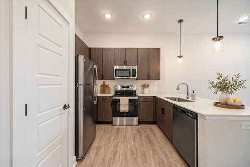 A modern kitchen with wooden cabinets and stainless steel appliances.