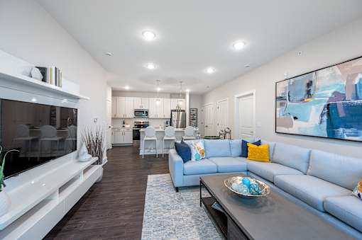A modern living room with a grey sofa and a wooden coffee table.