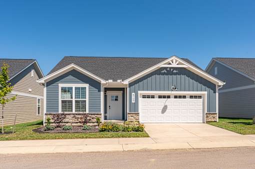 A house with a grey garage door and a white door.