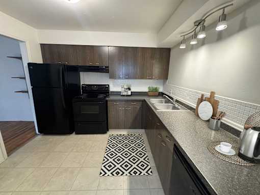 a kitchen with a black refrigerator and a sink