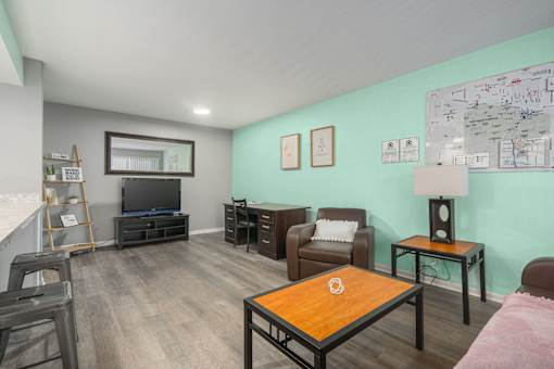 A living room with a wooden coffee table and a flat screen TV.