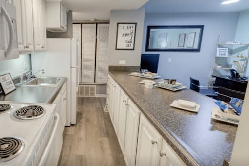 A kitchen with white appliances and cabinets.