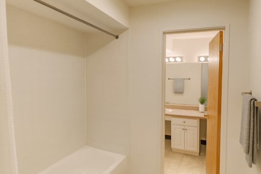 A white bathroom with a mirror and a white sink.