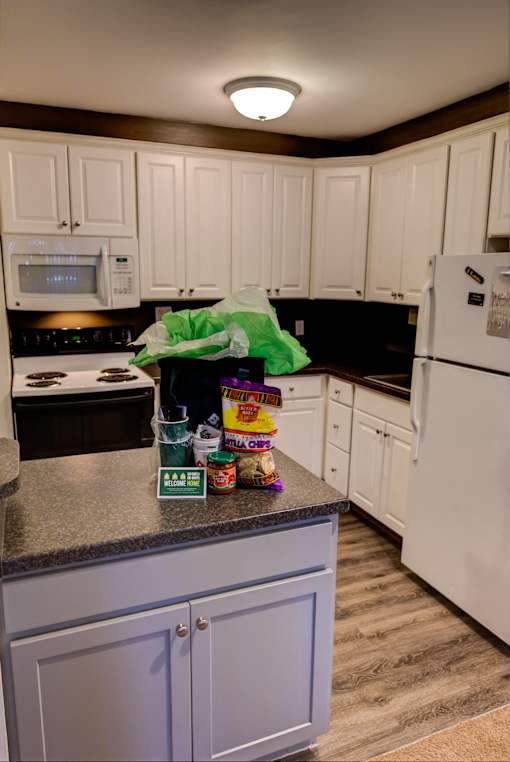 a kitchen with white cabinets and a counter with food on it