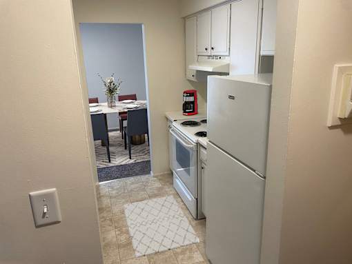a kitchen with a refrigerator and a stove and a dining room