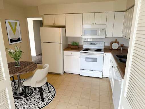 a kitchen with white appliances and a dining room table