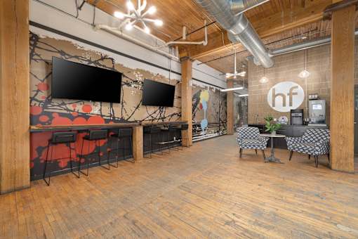 a large open space with wood floors and a mural on the wall
