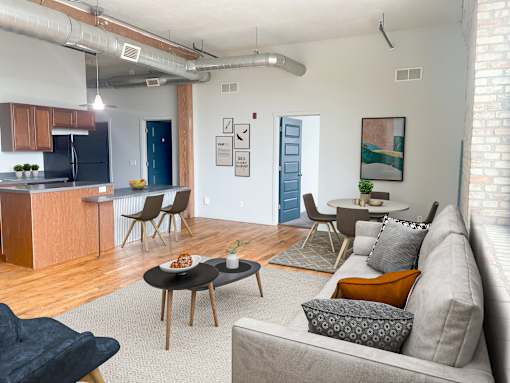 an open living room and kitchen area with a couch table and chairs and a kitchen with a