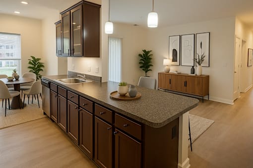 A modern kitchen with dark brown cabinets and a granite countertop.