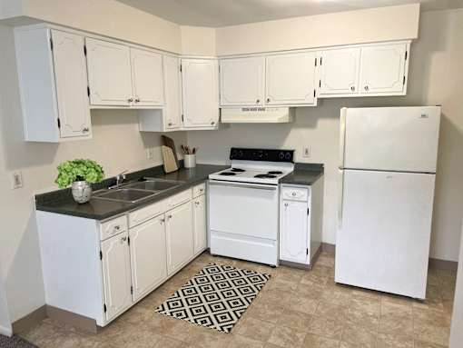 a kitchen with white appliances and white cabinets
