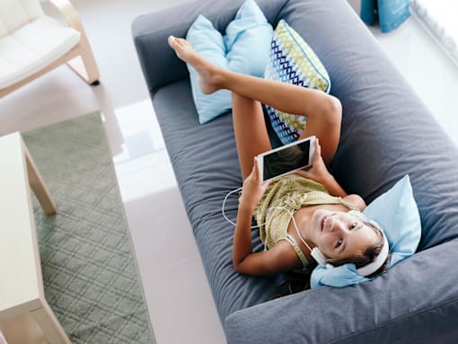 Teecn relaxing on couch at Living room at Southfield MI Apartments | 42 West Apartments in Southfield Michigan