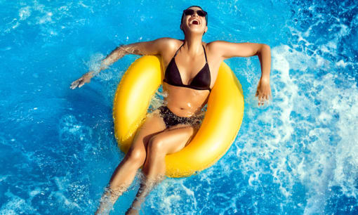 a woman in a swimming pool with a yellow raft